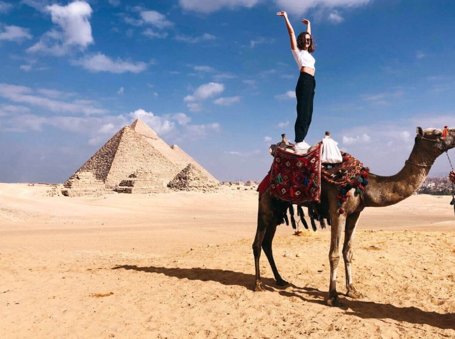 A-wonderful-shot-of-a-female-tourist-standing-on-a-camel